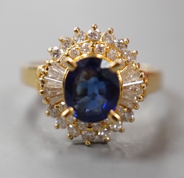 A modern 750 yellow metal, sapphire and diamond set oval cluster ring, size H, gross weight 4.6 grams.